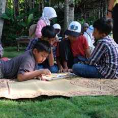 children reading together outdoors on picnic