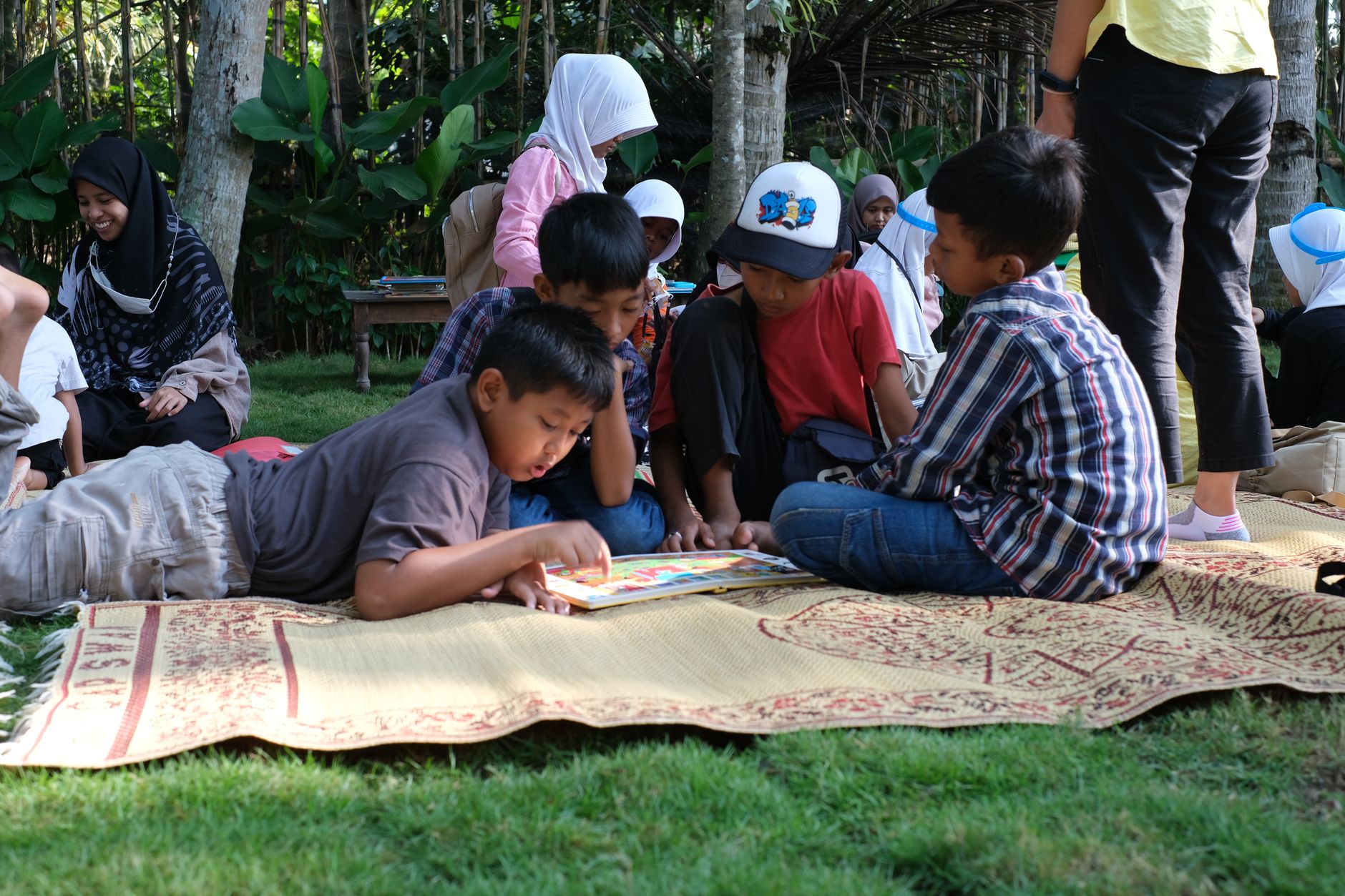 children reading together outdoors on picnic